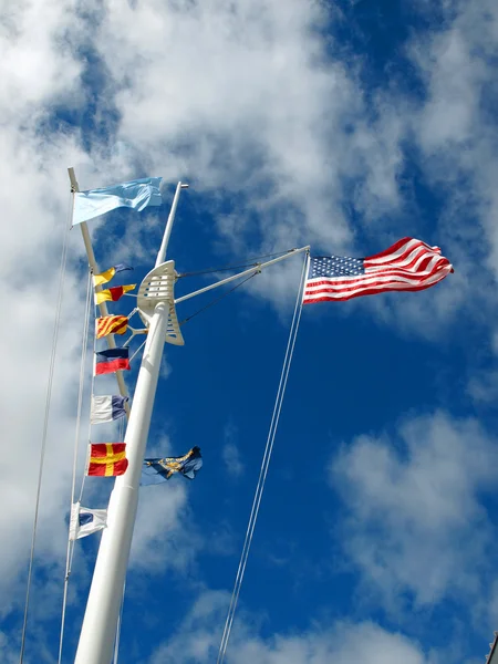 Banderas náuticas y americanas colgando de un mástil de barco con Wisp Imagen De Stock