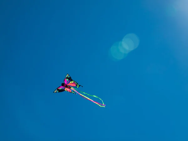 Bunte Drachen fliegen in wolkenlosem blauen Himmel — Stockfoto