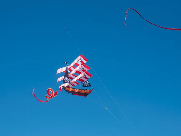 Kleurrijke piraat schip vliegeren in wolkenloze blauwe hemel — Stockfoto