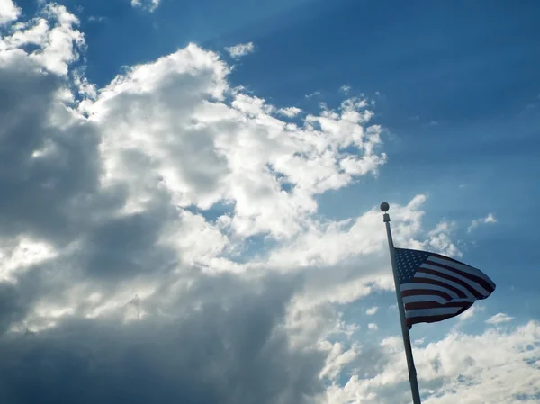 Η αμερικανική σημαία που κρέμεται πριν από σύννεφα και ηλιαχτίδες — Φωτογραφία Αρχείου