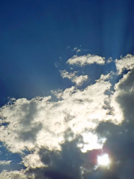 Οι ακτίνες του ήλιου λάμπει πίσω από γκρίζα και άσπρα σύννεφα — Φωτογραφία Αρχείου