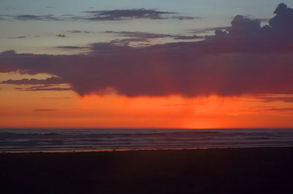 Cloudy Sunset Over the Ocean with Sunbeams in the Sky
