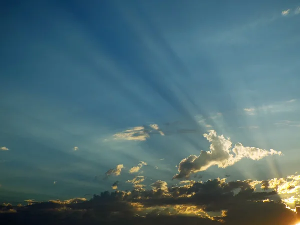 Wolkenverhangener Sonnenuntergang über dem Meer mit Sonnenstrahlen am Himmel — Stockfoto