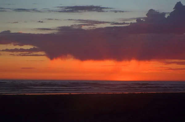 Coucher de soleil nuageux sur l'océan avec des vagues au premier plan — Photo