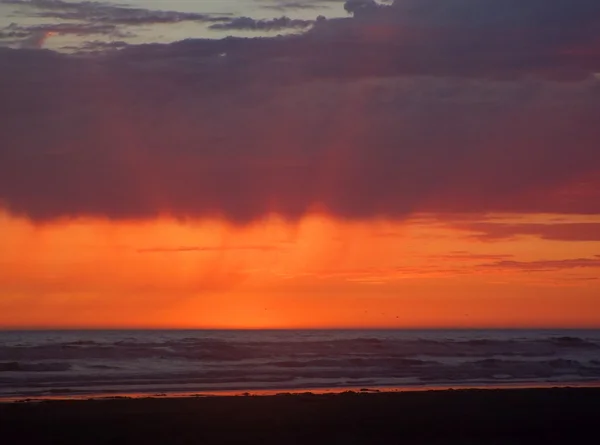 Coucher de soleil nuageux sur l'océan avec des vagues au premier plan — Photo