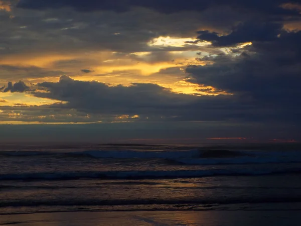 フォア グラウンドでの波と海の上曇り日没 — ストック写真