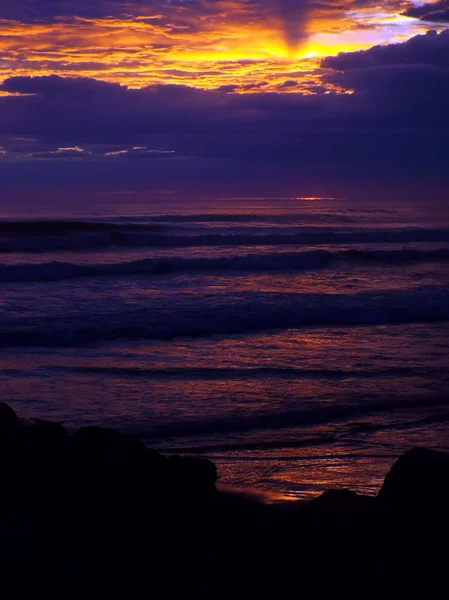 Coucher de soleil nuageux sur l'océan avec des vagues au premier plan — Photo