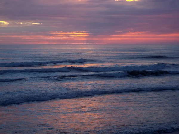 Tramonto nuvoloso sull'oceano con onde in primo piano — Foto Stock