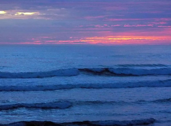 Nublado atardecer sobre el océano con olas en primer plano — Foto de Stock