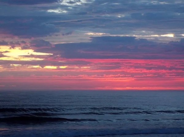 Nublado atardecer sobre el océano con olas en primer plano — Foto de Stock