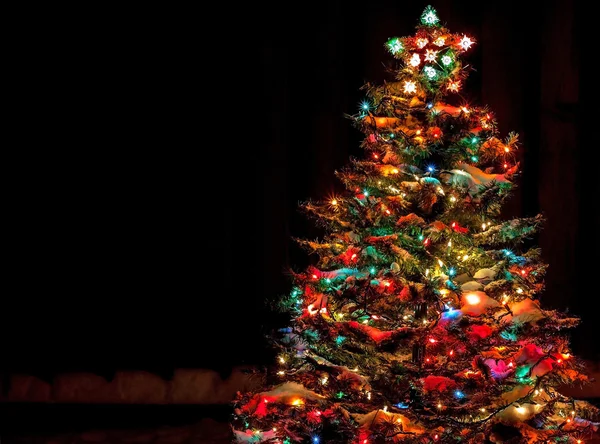 Arbre de Noël recouvert de neige avec lumières multicolores — Photo