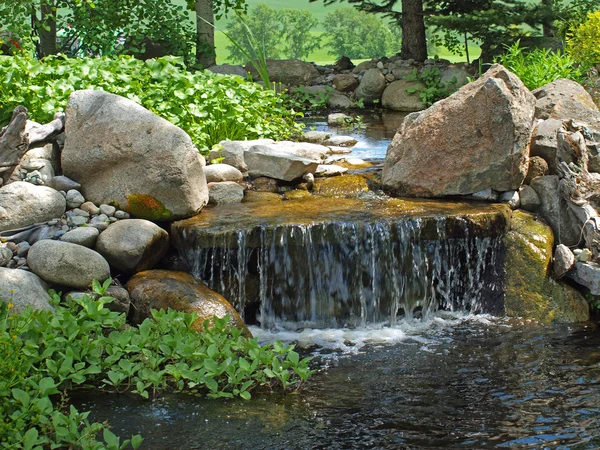 Bello stagno e con una piccola cascata rocciosa — Foto Stock