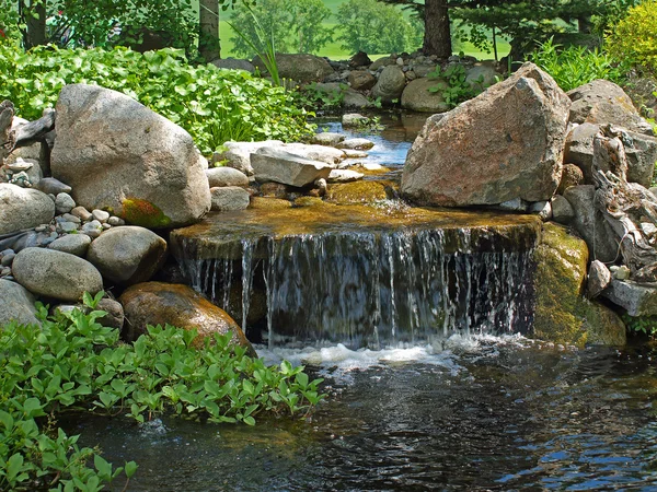 Bello stagno e con una piccola cascata rocciosa — Foto Stock