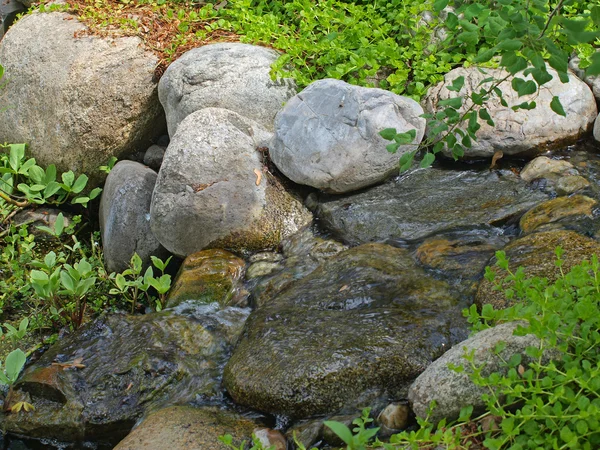 Schöner Teich und mit einem kleinen, felsigen Wasserfall — Stockfoto