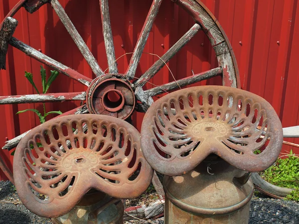 Rueda de carro de madera vieja y dos asientos de metal — Foto de Stock