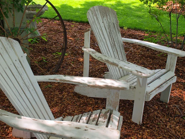 Beyaz ahşap Adirondack sandalyeler dışında bir bahçede — Stok fotoğraf