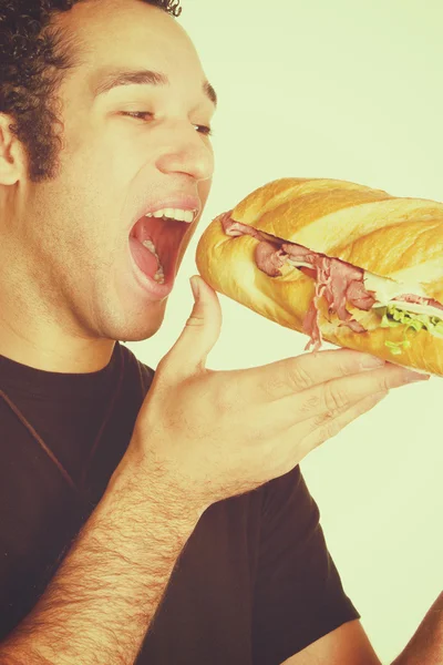 Homem mordendo sanduíche — Fotografia de Stock