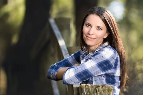 Mulher encostada à cerca — Fotografia de Stock