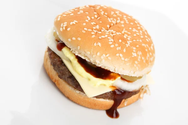 Hamburguesa con salsa de tomate y fondo blanco Imagen de archivo