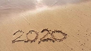 2020 'de kumun üzerinde yazanlar dalga tarafından silinip gidiyor.