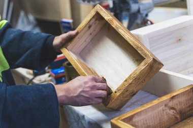 Ahşap kutuyu kahverengiye boyayan adam