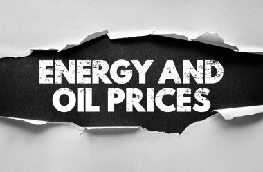 ENERGY AND OIL PRICES message displayed under torn paper concept illustrating economy, global finance, and market analysis with focus on fuel and energy cost trends