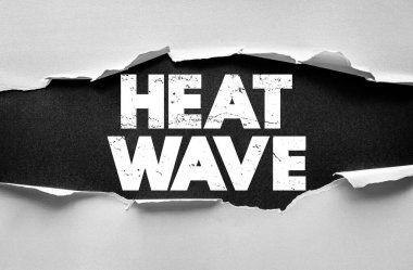 Yırtık kağıt arka planda sıcak dalga metni. İklim sıcaklığı, küresel ısınma ve sıcak yaz havası kavramı. Çevresel ısı riski ve güvenlik farkındalığı