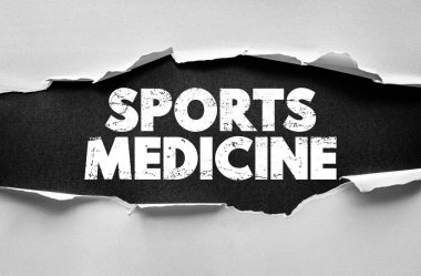 Spor tıp metni yırtık kağıdın altında fizik tedavi, rehabilitasyon, iyileşme, yaralanma bakımı ve tıbbi sağlık konseptinde profesyonel atletik tedaviyi sembolize ediyor.