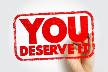 Motivasyon ve ödülü vurgulayan, bir el tarafından tutulan cesur bir damga olarak gösterilen mesajı hak ediyorsun. Fotoğraf, güçlü bir teşvik temalı görsel efekt sunan, desenli bir çerçeve efekti ile net harfleri vurgular