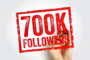 Sınırlı bir çerçeve içinde dokulu kalın harflerle damgalanmış 700K FOLLOWERS damgası, sosyal medya ilerlemesini, takip eden kilometre taşını veya dijital varlık büyümesini temsil eden bir işaret ile görünür bir el tarafından yaratıldı