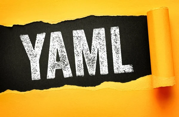 YAML metni yırtık kağıt arkaplan üzerinde kalın tipografi ile gösterilir, Aint Markup Dili anlamına gelir, genel olarak yapılandırma dosyaları ve veri alışverişi için kullanılan bir insan-okunabilir veri serileştirme biçimidir