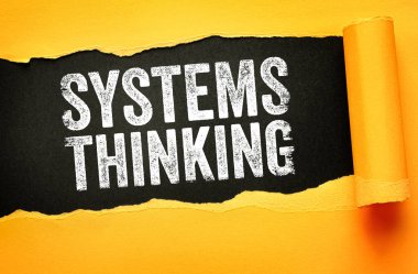 Yırtık kağıt arkaplanda gösterilen metinler bütünsel analizi, birbirine bağlı unsurları, problem çözme yaklaşımlarını, karmaşıklık farkındalığını ve ilişkilerin stratejik anlayışını sembolize ediyor.