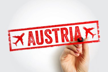 Avusturya yazılı pulu beyaz arka planda elle tutuluyor. Kırmızı kauçuk pul efektli seyahat hedefi konsepti, uçak simgeleri ve tatil planlama ve seyahatler için insan eli işaretleyicisi..