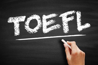 Tahtaya tebeşirle yazılmış yabancı bir dil olarak İngilizce Testi 'nin TOEFL kısaltması. El tebeşirle altı çizili harfleri tutar. İngilizce yeterliliği ve uluslararası öğrenim kavramı