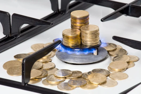 Golden coins on gas cooker — Stock Photo, Image