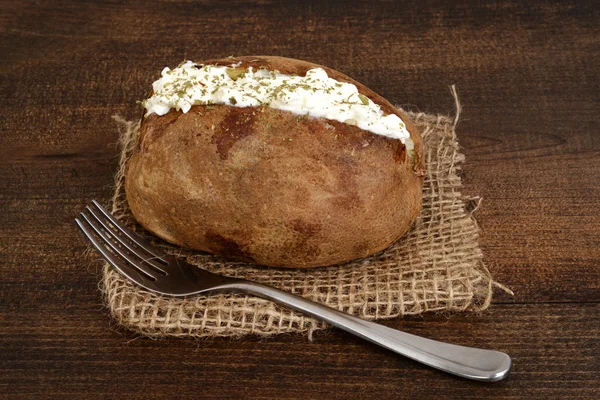 Baked potato with sour cream and ground chives — Stock Photo, Image