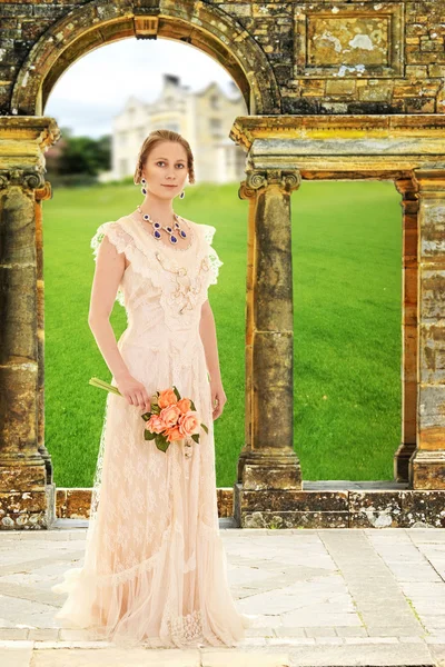 Mujer victoriana en jardín por arco de piedra —  Fotos de Stock