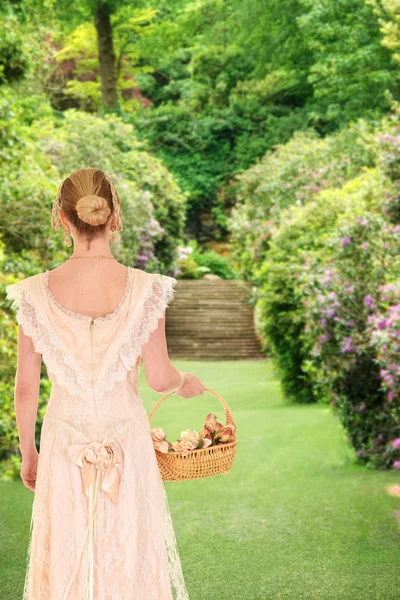 Mujer victoriana caminando en el jardín con rosas — Foto de Stock