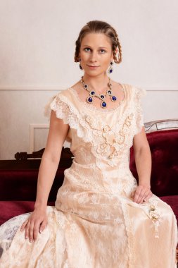 Victoria kadın kırmızı kanepede oturan