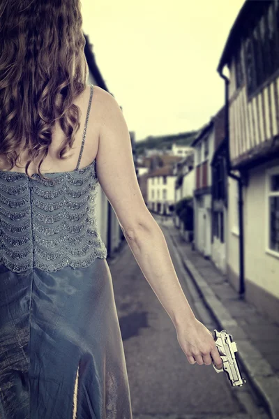 Mulher de vestido com pistola na rua — Fotografia de Stock