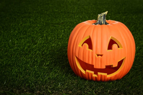 Scary pumpkin on grass — Stock Photo, Image