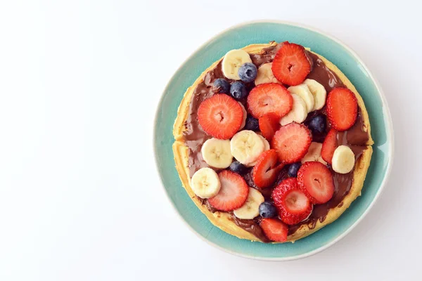 Blauer Teller Mit Gemischten Früchten Und Schokoladenaufstrich Auf Waffel Stockbild