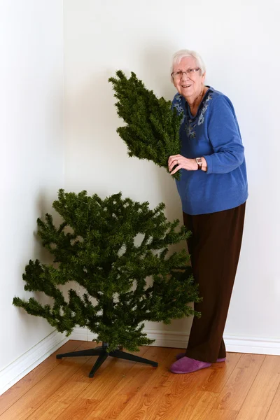 Seniorin mit gefälschtem Weihnachtsbaum — Stockfoto
