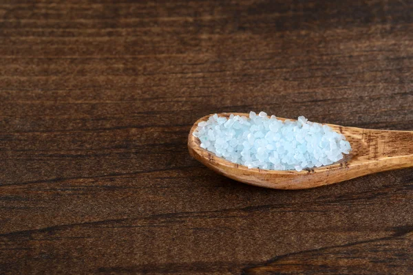 Closeup bath salts in wood spoon — Stock Photo, Image