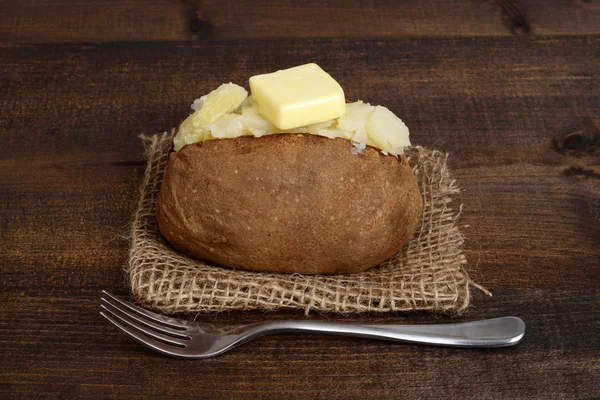 Baked potato with butter and fork — Stock Photo, Image