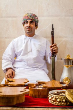 Bir masanın arkasında bir tüfekle omani adam