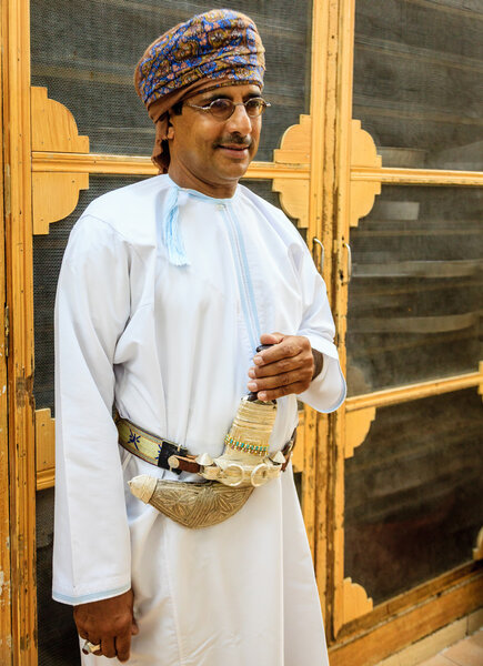 Omani man in a traditional outfit wearing khanjar