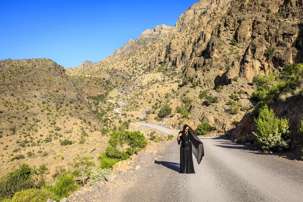 Одинокая женщина на горной дороге — стоковое фото