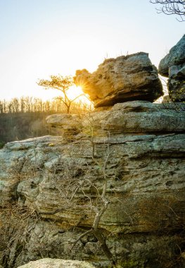 Berea, Kentucky 'deki Pinnacles yürüyüş alanındaki kayaların arkasından parlayan güneş.