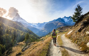 İsviçre 'nin Zermatt tatil köyü yakınlarındaki dağlarda yürüyen genç bir kadın.